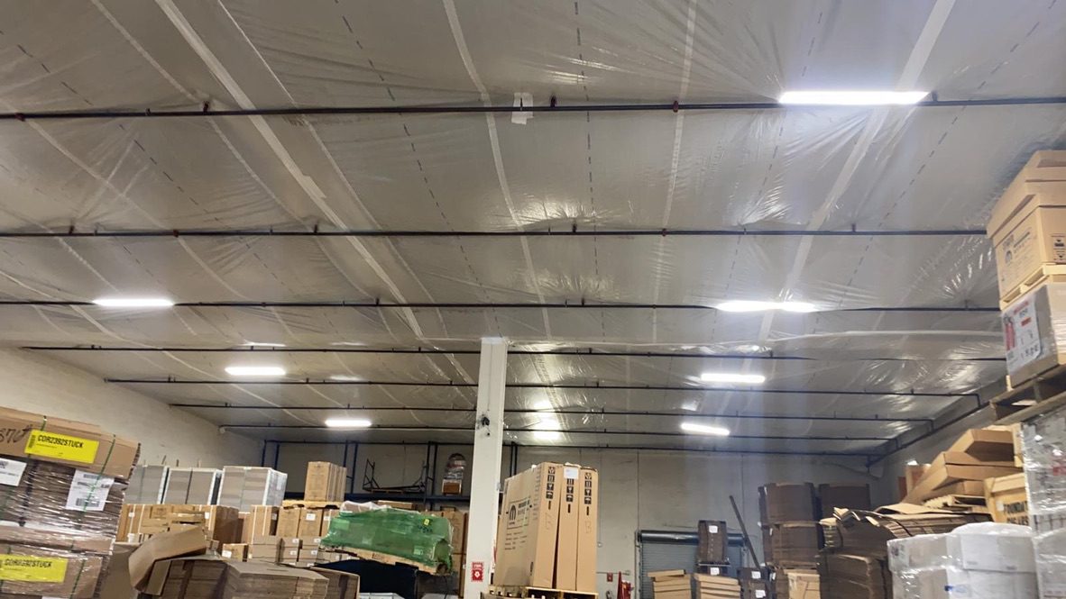 A warehouse with boxes and lights on the ceiling.