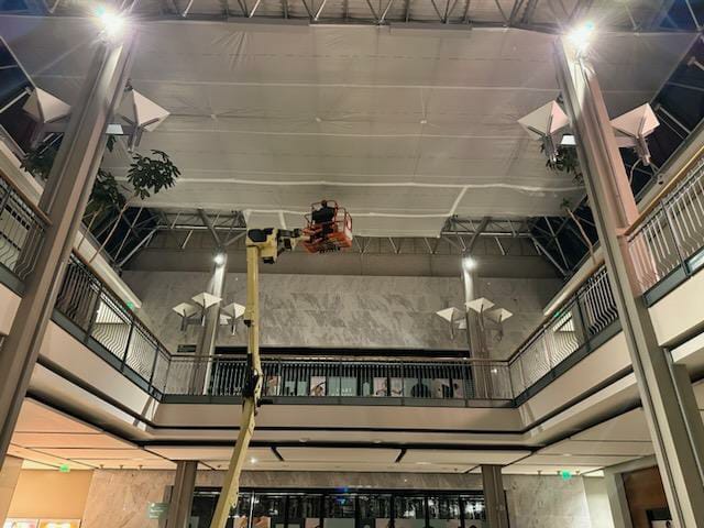 A man is on the lift in an atrium.